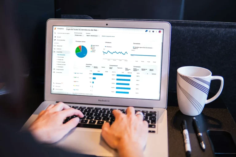 Ordinateur portable affichant un rapport d'audience, à côté d'une tasse