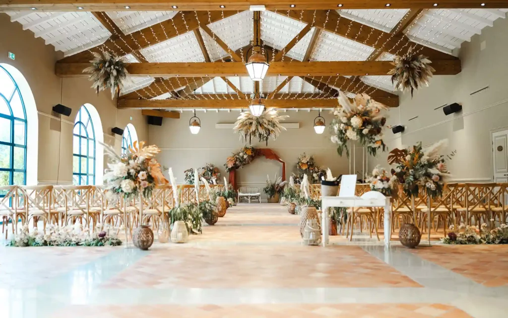 Salle de réception de mariage avec charpente apparente et décoration florale