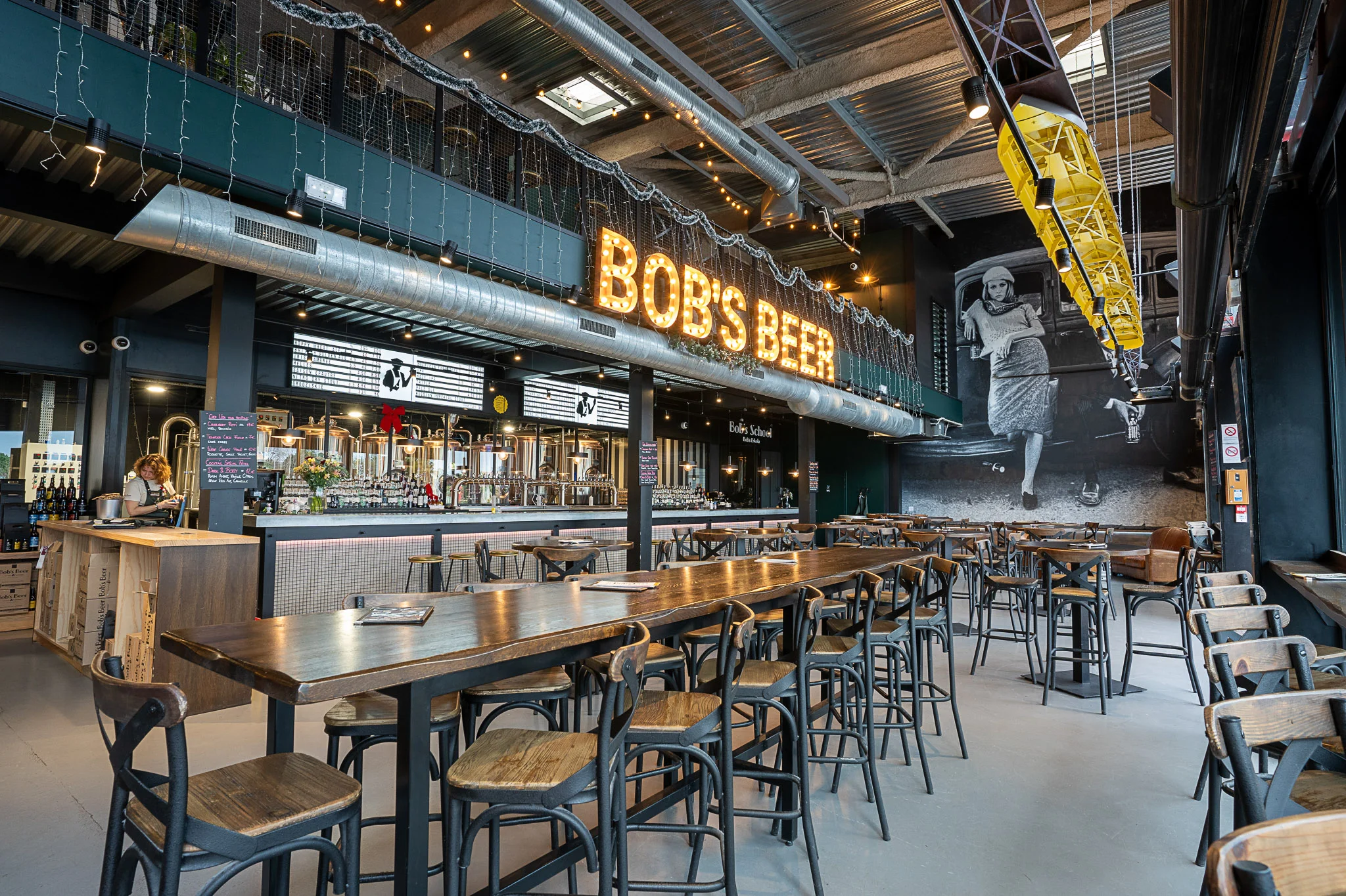 Vue intérieure d’un bar à l’ambiance industrielle avec enseigne lumineuse - Photographie d’architecture