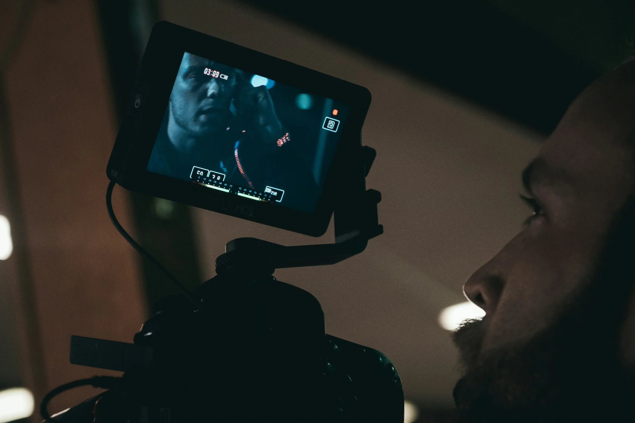 Cameraman filmant une scène avec un écran de contrôle, lors d’une production vidéo réalisée par notre agence de communication.