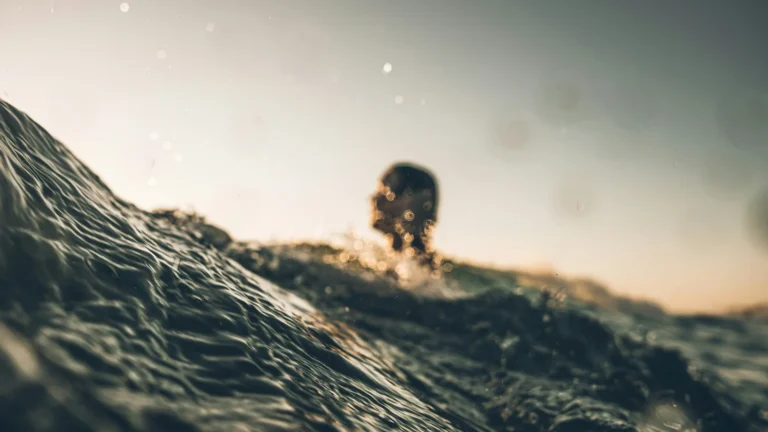 Surfeur au ras de l’eau au coucher du soleil, réalisation Biarritz Surfshop