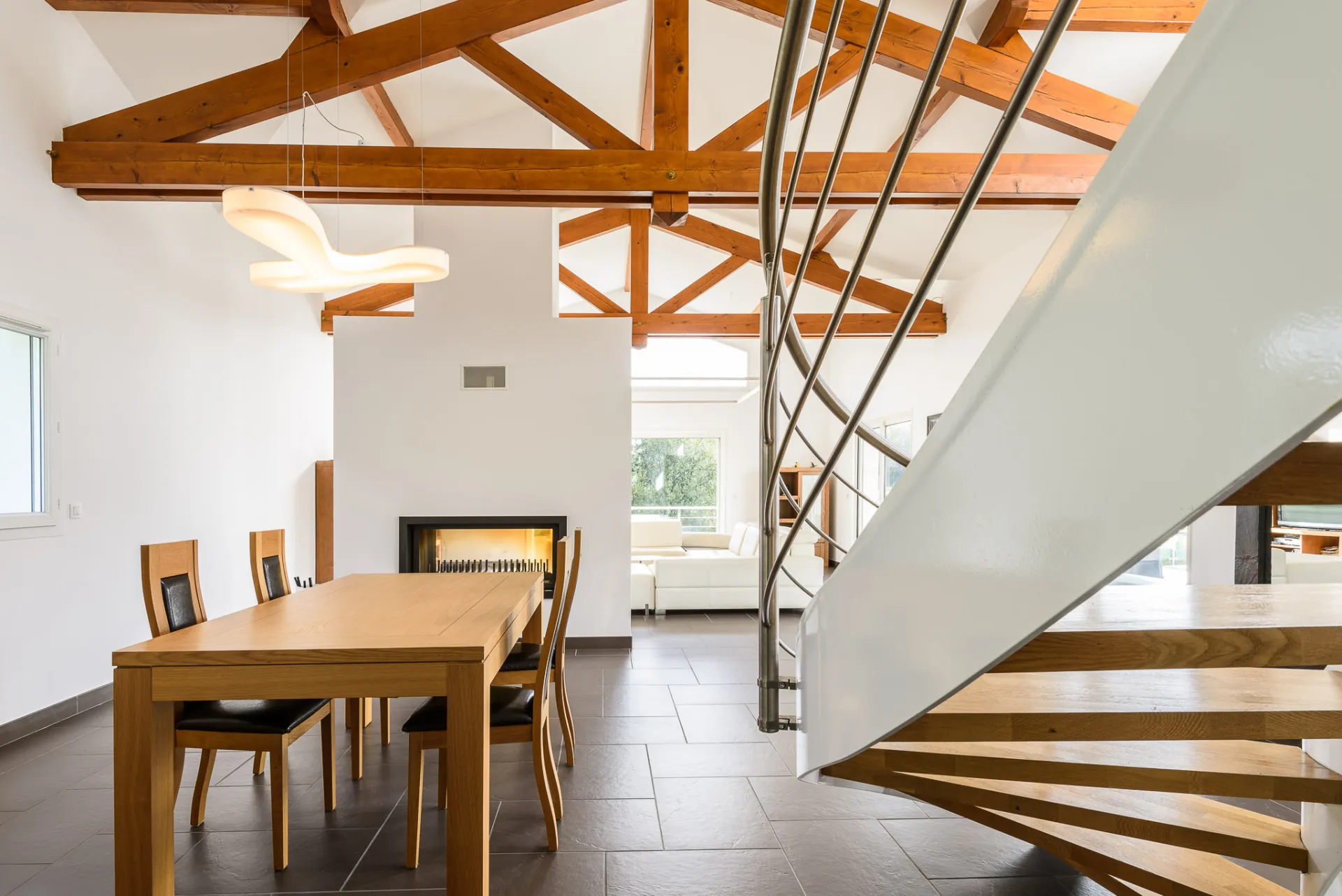 Intérieur sous charpente en bois avec escalier hélicoïdal, réalisation Castors Basques
