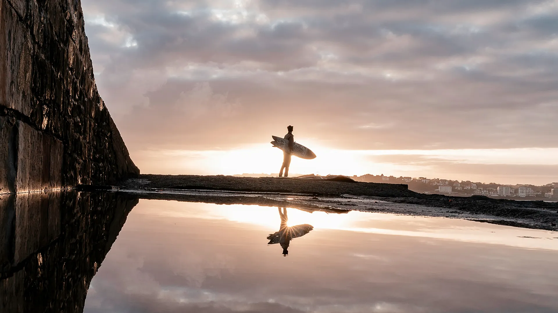 Surfeur au coucher du soleil se reflétant sur la plage, réalisation Mindurry Promotion